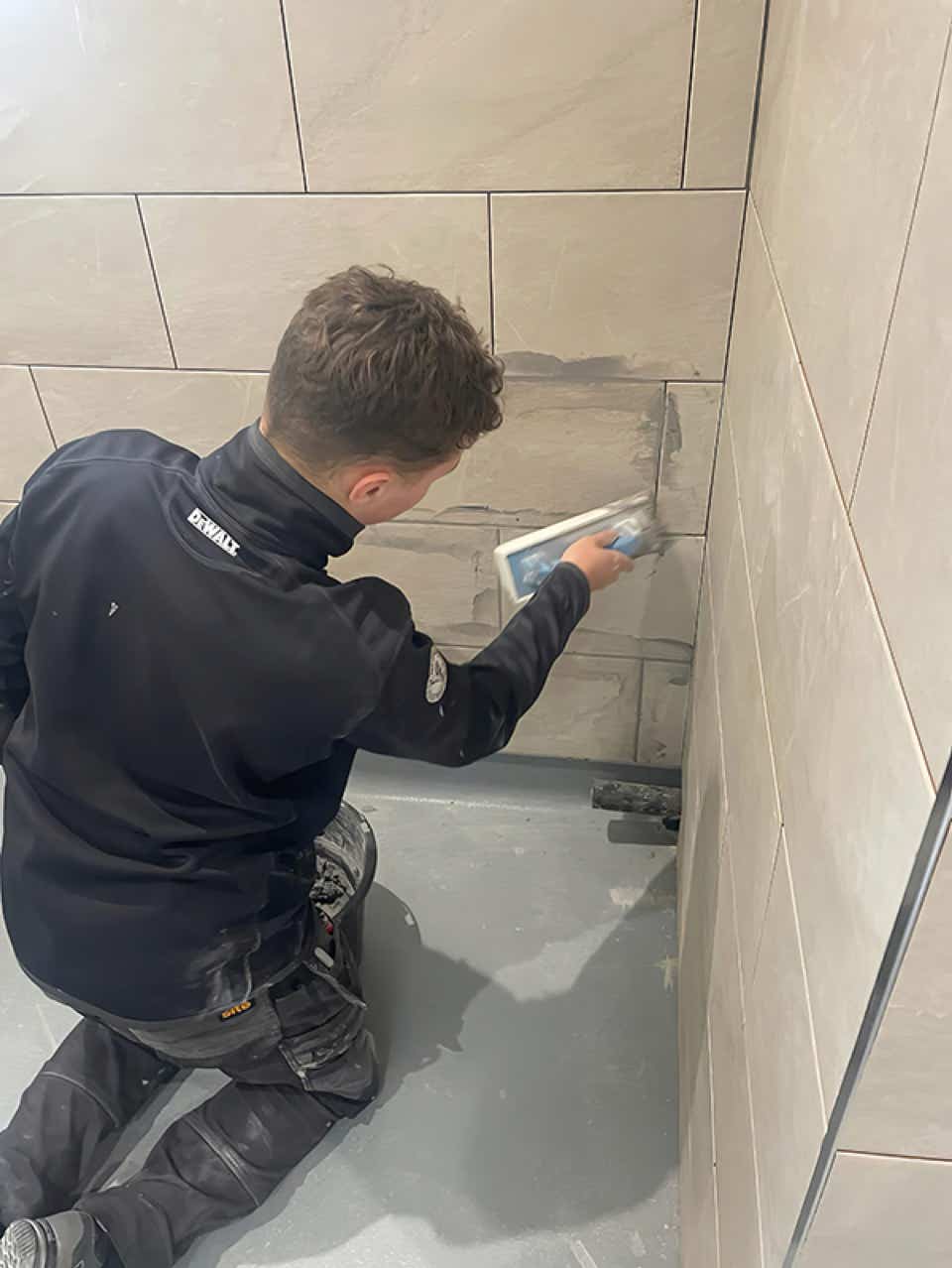 Accredited Plumb Yorkshire Ltd. tradesman applying grouting.