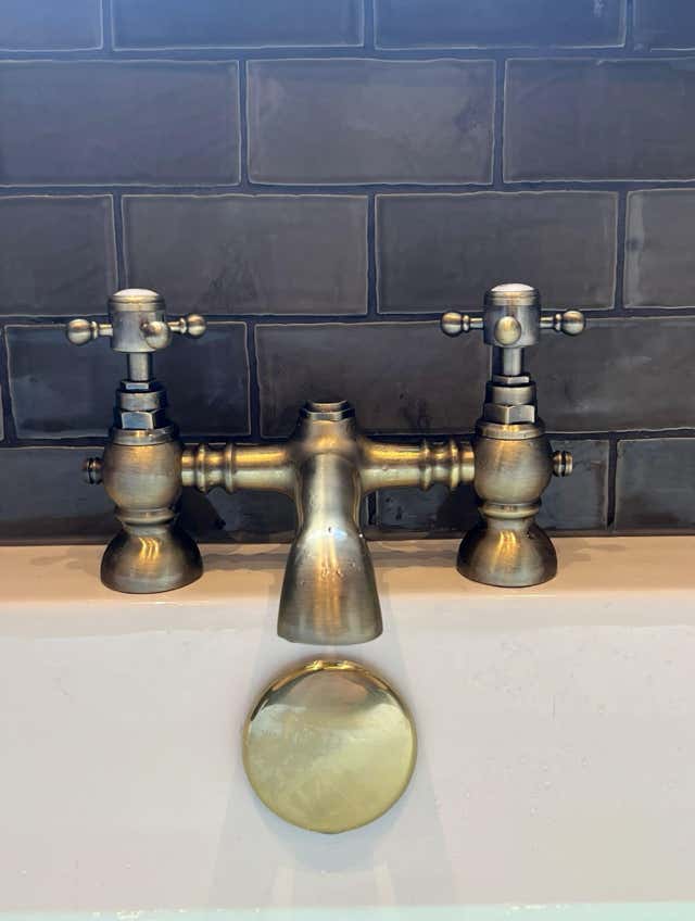 Vintage bathroom taps in front of dark tiled backdrop by Plumb Yorkshire.
