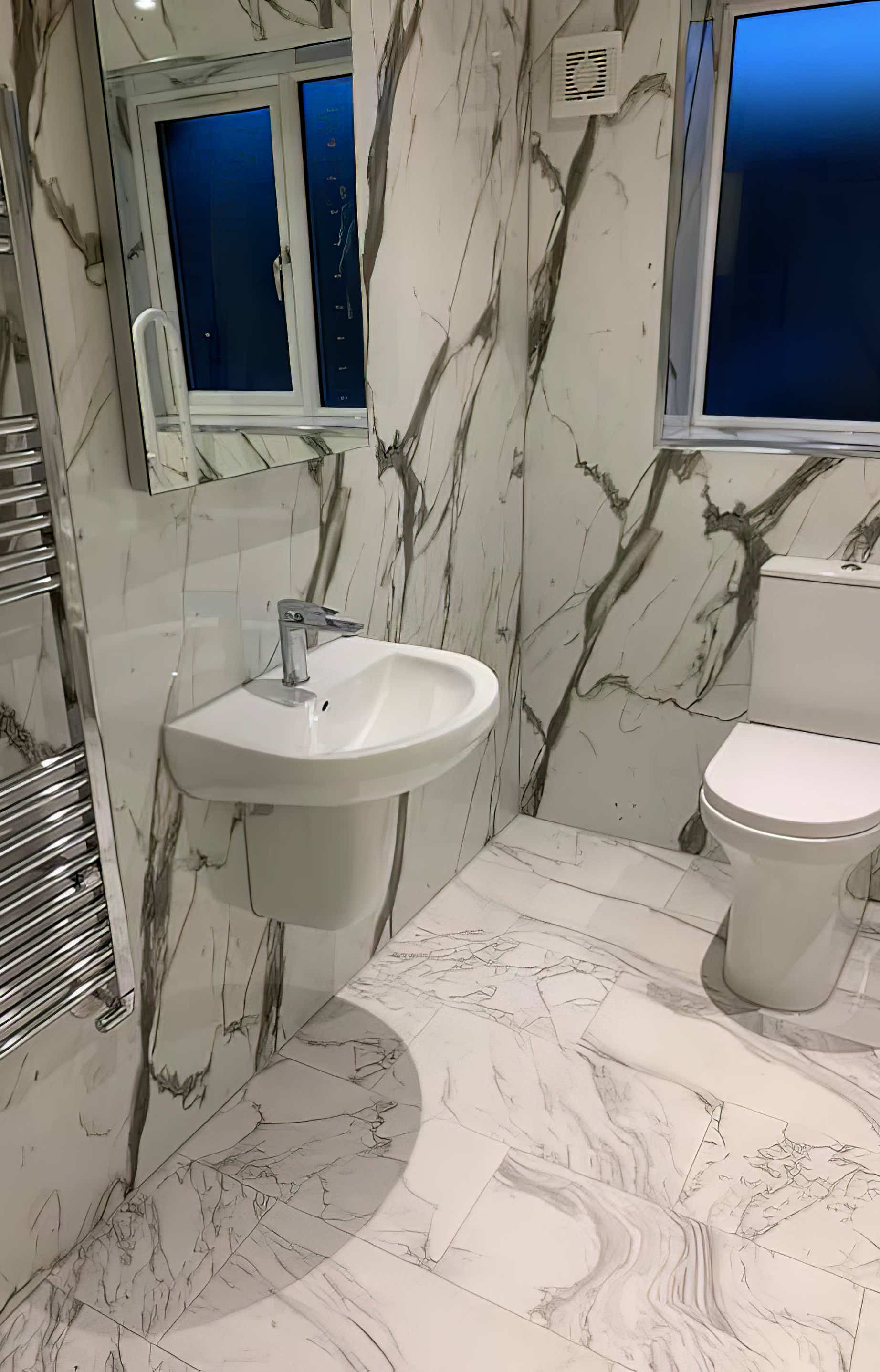 Modern white with grey flecks wet wall panels in a bathroom fitted by Plumb Yorkshire Ltd.